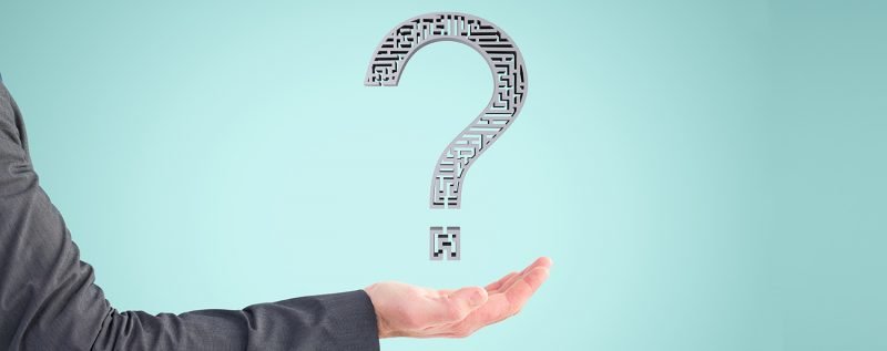 composite of hand holding questionmark graphic with blue background