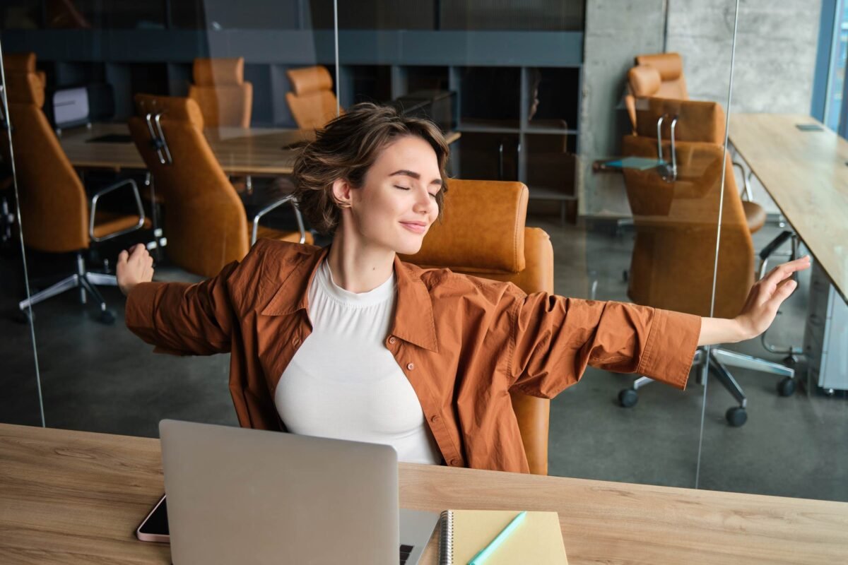 Moça abrindo os braços, feliz no trabalho